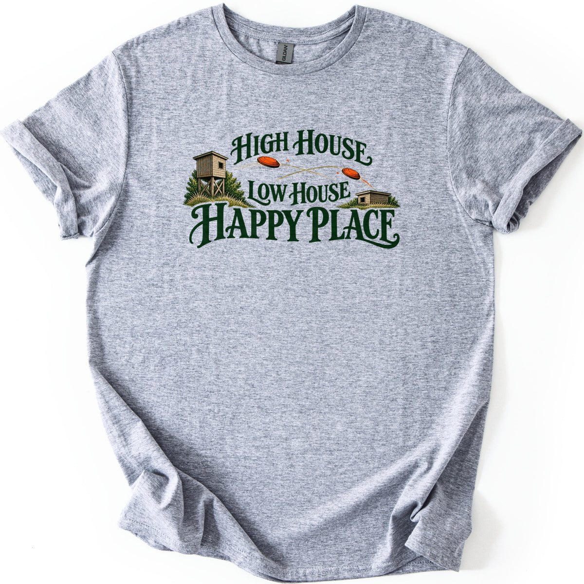 High House Low House Happy Place Comfort Colors T-shirt in Sport Grey, laid flat. Dark green lettering reads High House Low House Happy Place, with a tall wooden skeet tower on the left, a low shed on the right, and two orange clay targets in flight. Cuffed sleeves on a white surface.
