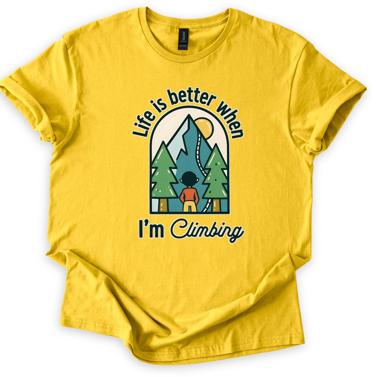 Better When I'm Climbing Comfort Colors T-shirt in Daisy, laid flat. The words Life is better when arch over a window scene of a person facing a teal mountain with a winding trail, a yellow sun and two pine trees, with I'm Climbing below. Sleeves rolled, on a white surface.
