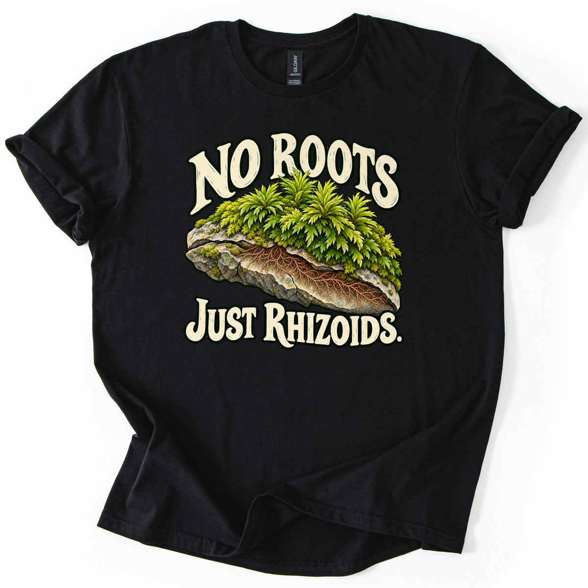 No Roots Just Rhizoids Comfort Colors T-shirt in Black, laid flat. Leafy green moss sits on a gray rock with a cutaway of brown threadlike rhizoids, framed by cream words reading No Roots and Just Rhizoids. The shirt lies on a white background with cuffed sleeves.