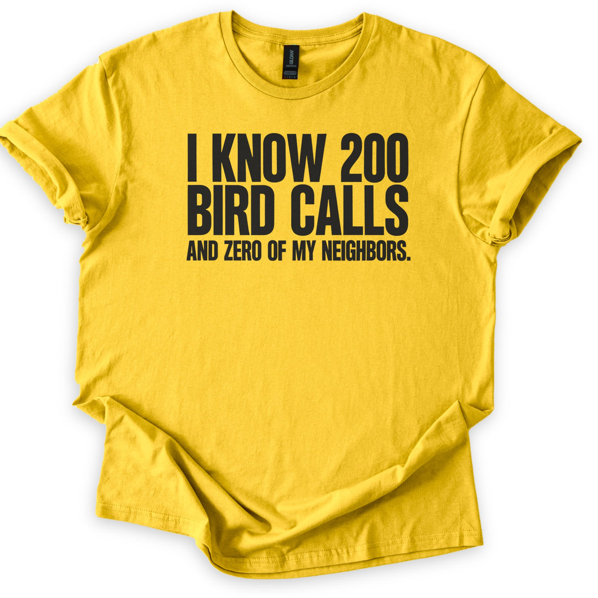 I Know 200 Bird Calls and Zero of My Neighbors Comfort Colors T-shirt in Daisy, laid flat. Bold black capital letters across the chest read I Know 200 Bird Calls and Zero of My Neighbors. The shirt lies on a white background with rolled sleeves and a loosely rumpled hem.