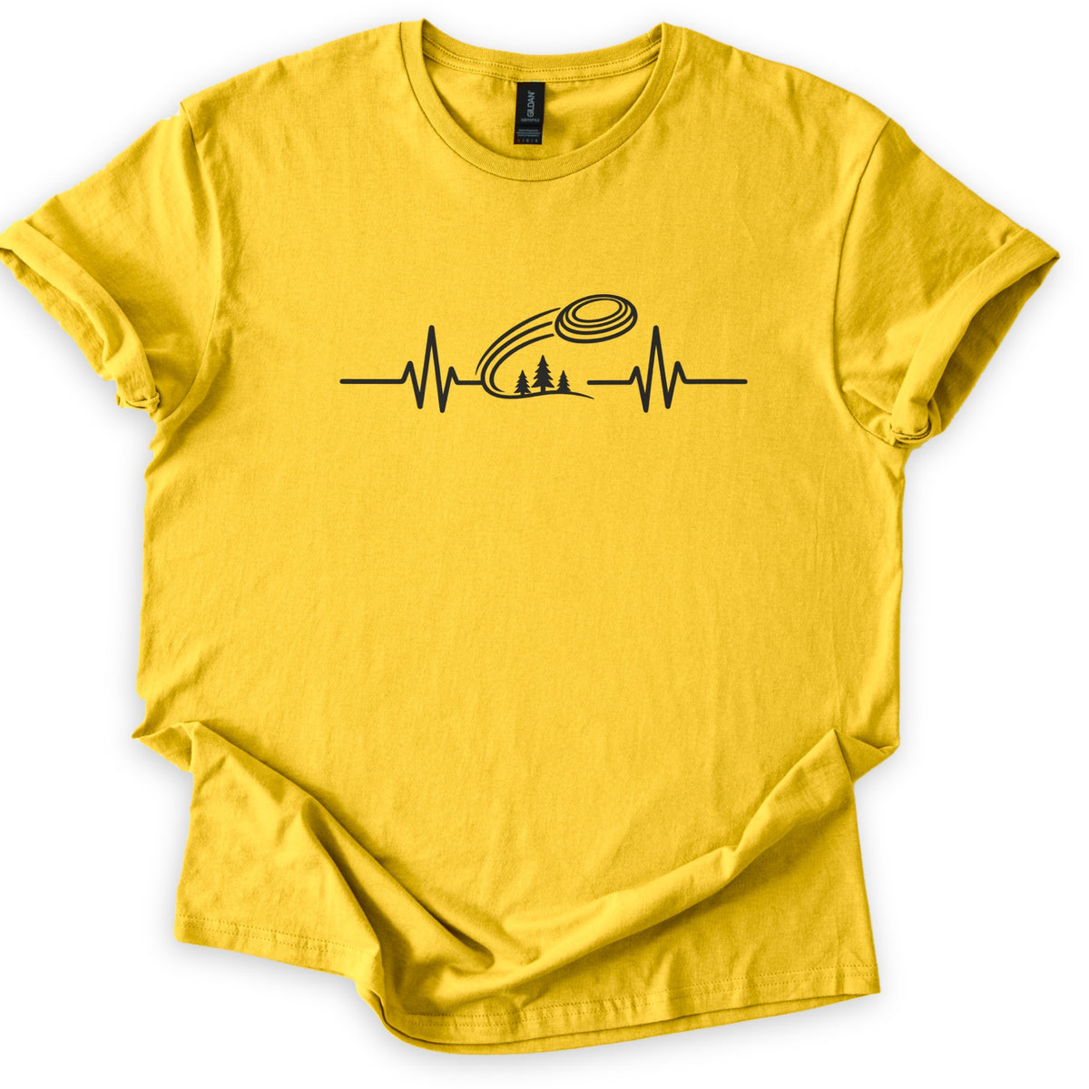Trap Shooting Heartbeat Comfort Colors T-shirt in Daisy, laid flat. A black heartbeat line with a clay target flying above three pine trees on a hill, with no words. The shirt lies on a white background with its sleeves rolled and the hem loosely folded.
