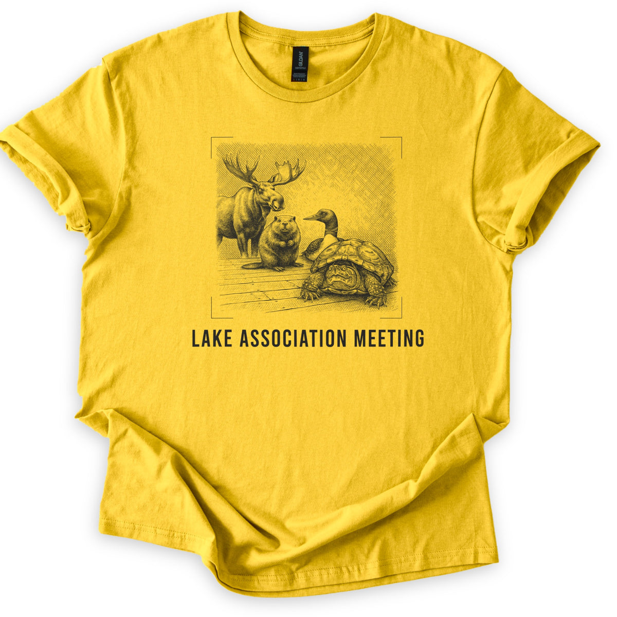 Lake Association Meeting Comfort Colors T-shirt in Daisy, laid flat. A black-ink etching of a moose, a beaver, a loon, and a frowning turtle gathered on a wooden dock, framed by corner marks, above the words Lake Association Meeting. Sleeves are cuffed on a white surface.