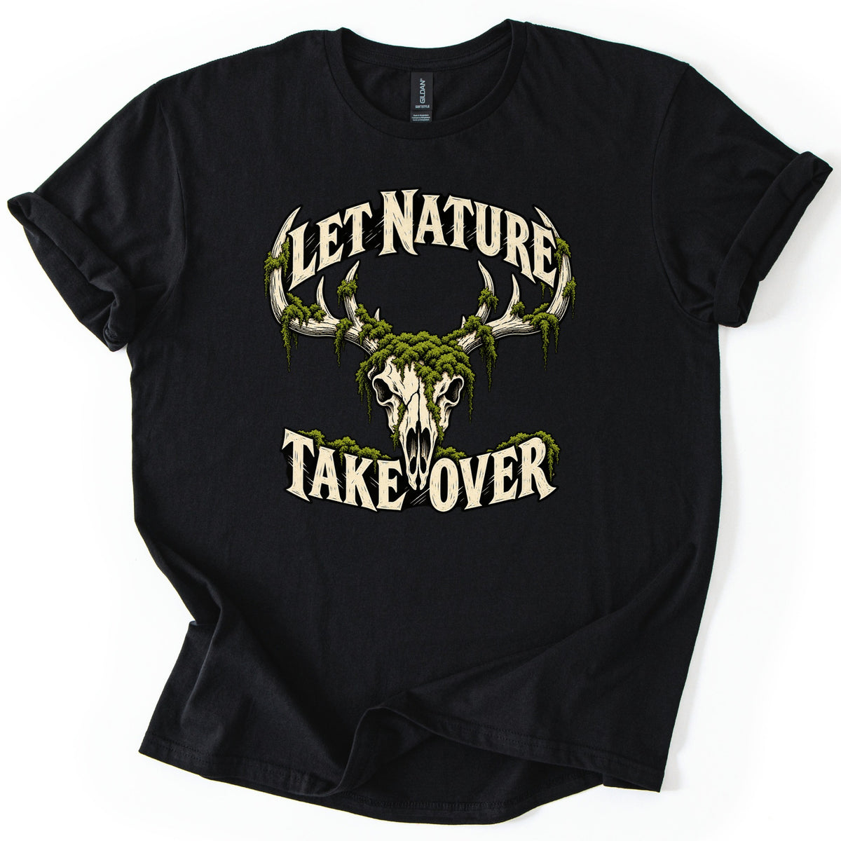 Let Nature Take Over Comfort Colors T-shirt in Black, laid flat. A cream deer skull with antlers draped in green moss sits between the words Let Nature arched above and Take Over below, in cream lettering. The sleeves are rolled on a plain white background.