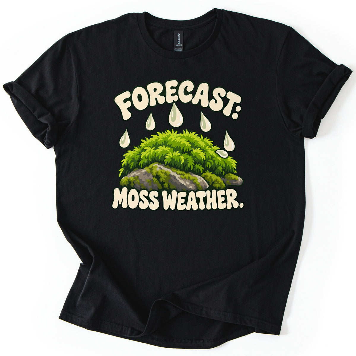 Forecast Moss Weather Comfort Colors T-shirt in Black, laid flat. Cream bubble letters read FORECAST: above white raindrops falling on a mound of bright green moss over gray rocks, with MOSS WEATHER. below. The shirt has rolled sleeves on a white background.