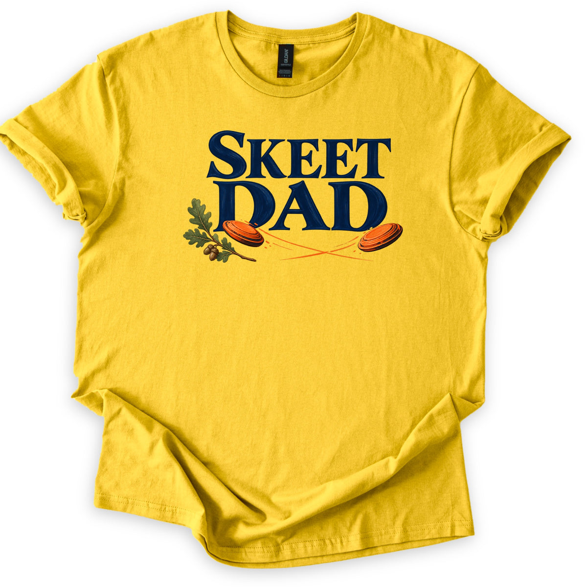 Skeet Dad Comfort Colors T-shirt in Daisy, laid flat. The words SKEET DAD in large navy letters, with an oak sprig and acorns on the left and two orange clay targets flying with crossing orange trails. Sleeves are cuffed, on a white background.
