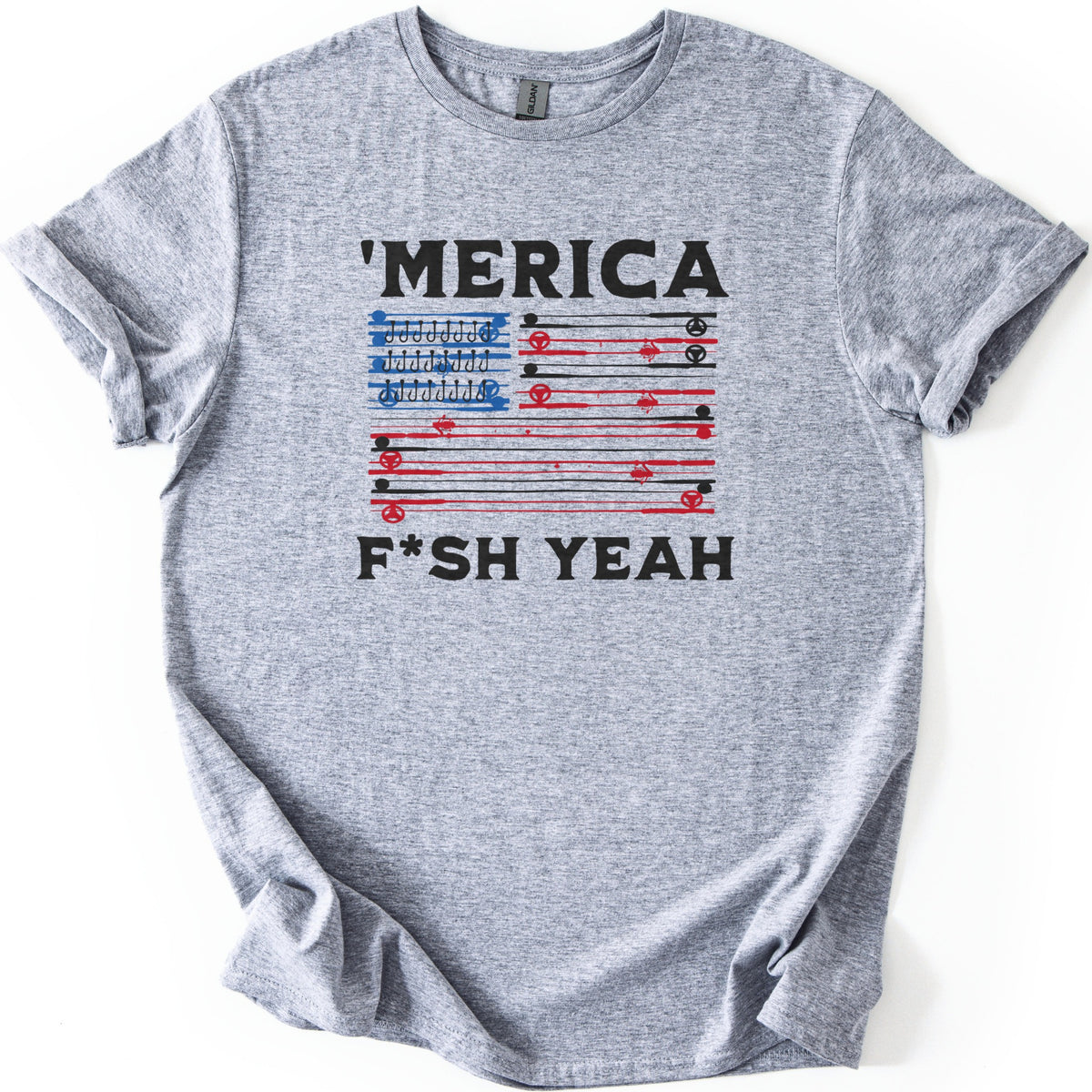 Fish America Fish Yeah Comfort Colors T-shirt in Sport Grey, laid flat. Black letters read 'MERICA above an American flag built from red and black fishing rods and reels, with rows of hooks in the blue corner, and F*SH YEAH below. Cuffed sleeves on white.