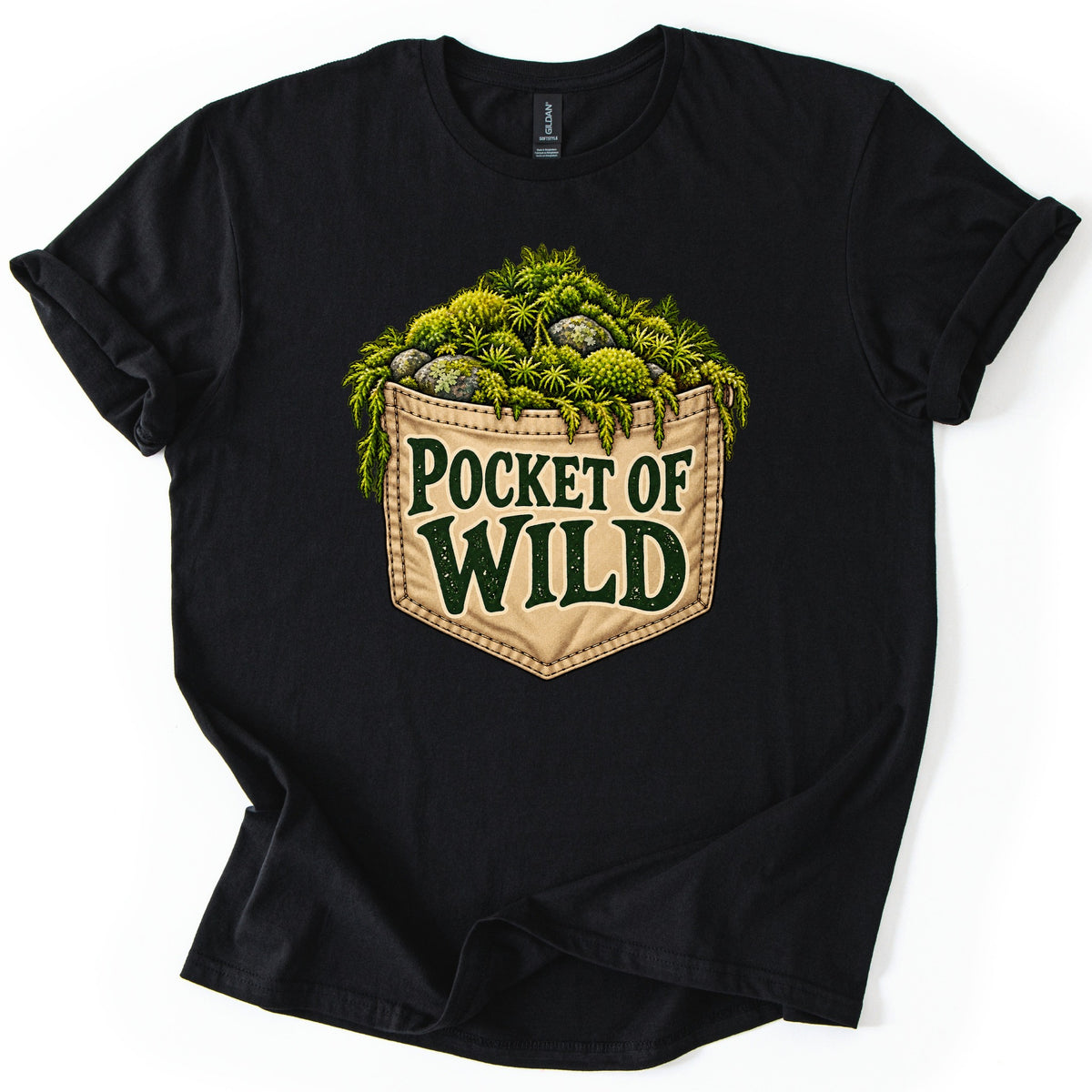 Pocket of Wild Comfort Colors T-shirt in Black, laid flat. A tan stitched pocket filled with green moss, ferns and lichen-covered rocks, with the words Pocket of Wild in dark green lettering. The shirt is laid on a white surface with its sleeves cuffed.