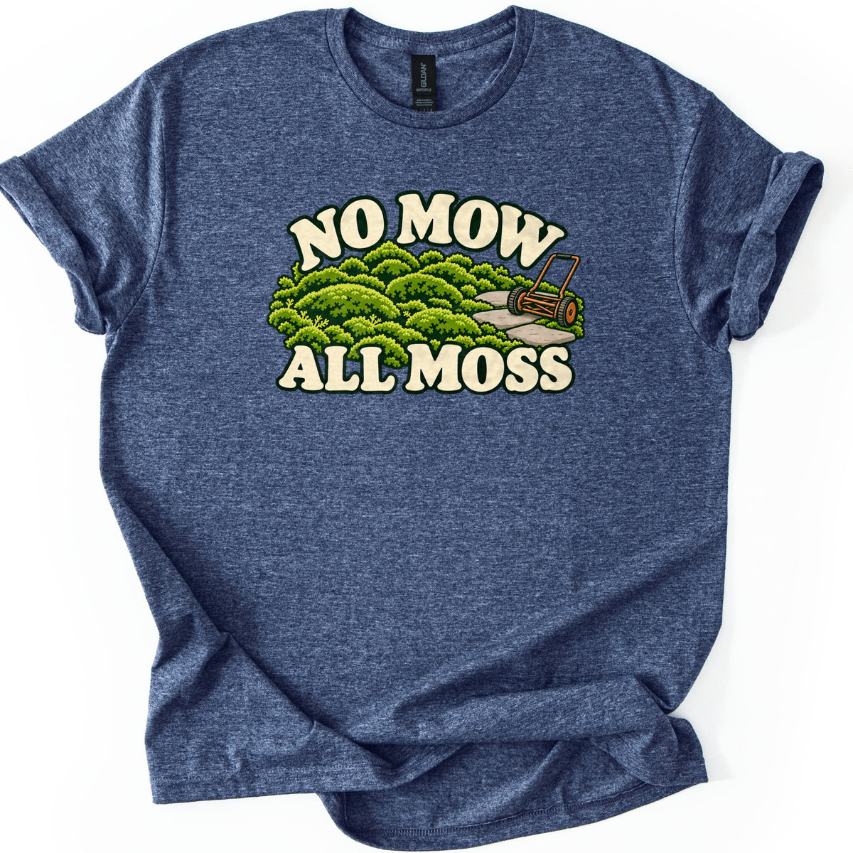 No Mow All Moss Comfort Colors T-shirt in Heather Navy, laid flat. Cream retro letters read No Mow above a cartoon of mounded green moss, a stone path and an old push reel mower, with All Moss below. The shirt lies on a white surface with cuffed sleeves.