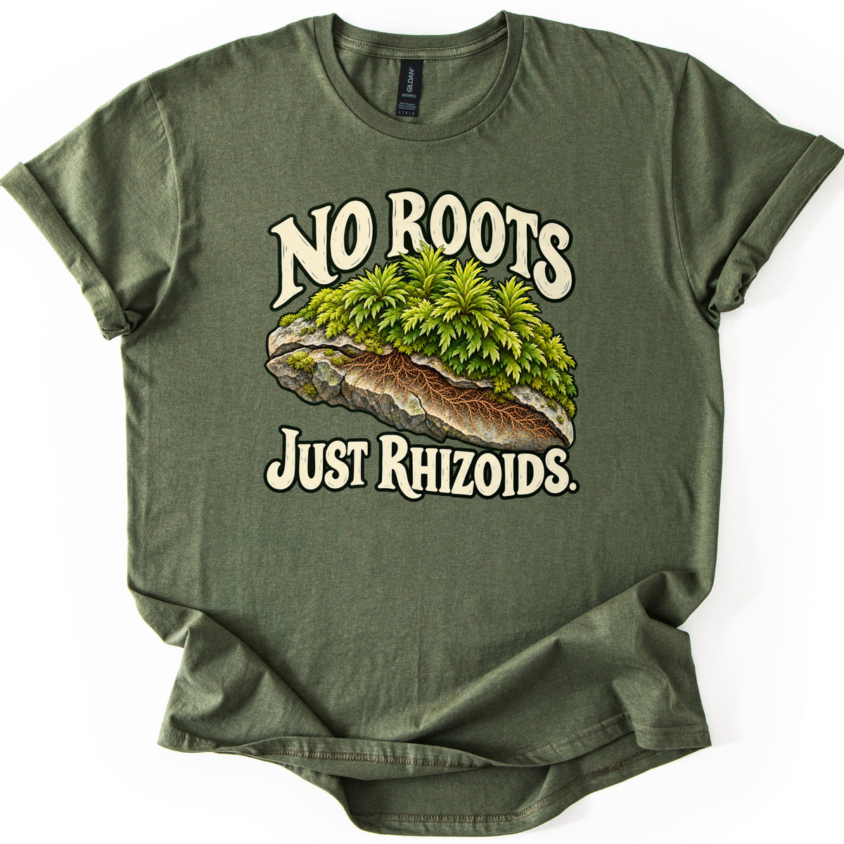 No Roots Just Rhizoids Comfort Colors T-shirt in Military Green, laid flat. Green moss tops a gray rock whose cut side shows brown threadlike rhizoids, with cream words reading No Roots above and Just Rhizoids below. The shirt lies on a white background with cuffed sleeves.
