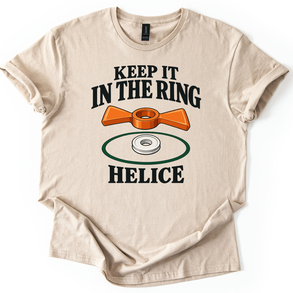 Keep It in the Ring Comfort Colors T-shirt in Sand, laid flat. An orange two-winged helice target sits above a white disc inside a green ring, between the words Keep It in the Ring and Helice. The shirt lies on a white background with cuffed sleeves and a folded hem.