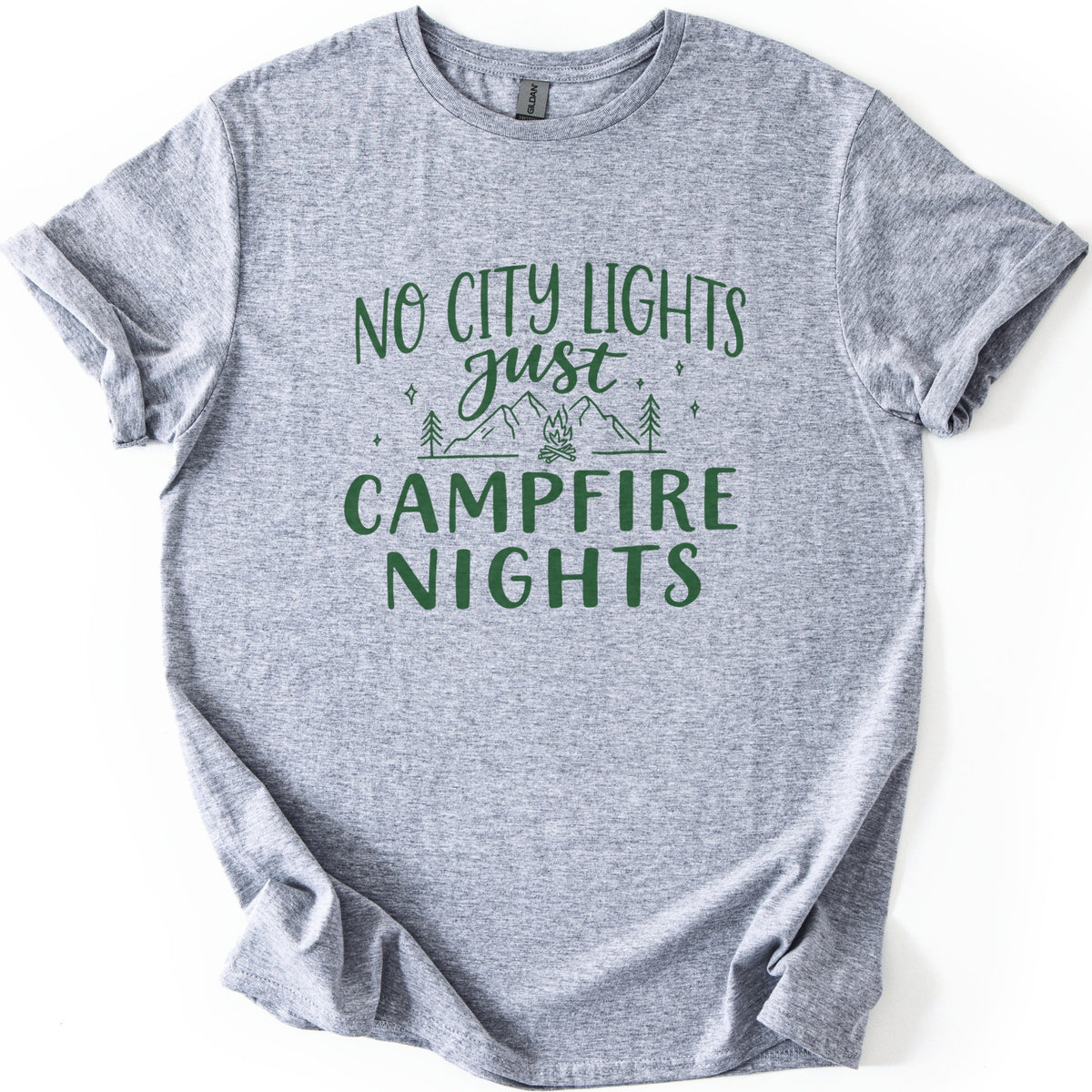 Campfire Nights Comfort Colors T-shirt in Sport Grey, laid flat. Dark green print reads No City Lights just Campfire Nights, with a line drawing of mountains, pine trees, stars and a small campfire. The sleeves are rolled and the shirt lies on a white background.
