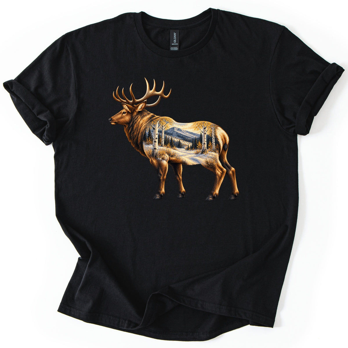 Aspen Pass Elk Comfort Colors T-shirt in Black, laid flat. A realistic bull elk stands facing left, its body filled with a snowy mountain trail lined with white aspens in golden leaves and dark pines. No words. The shirt lies on white, hem loosely folded.