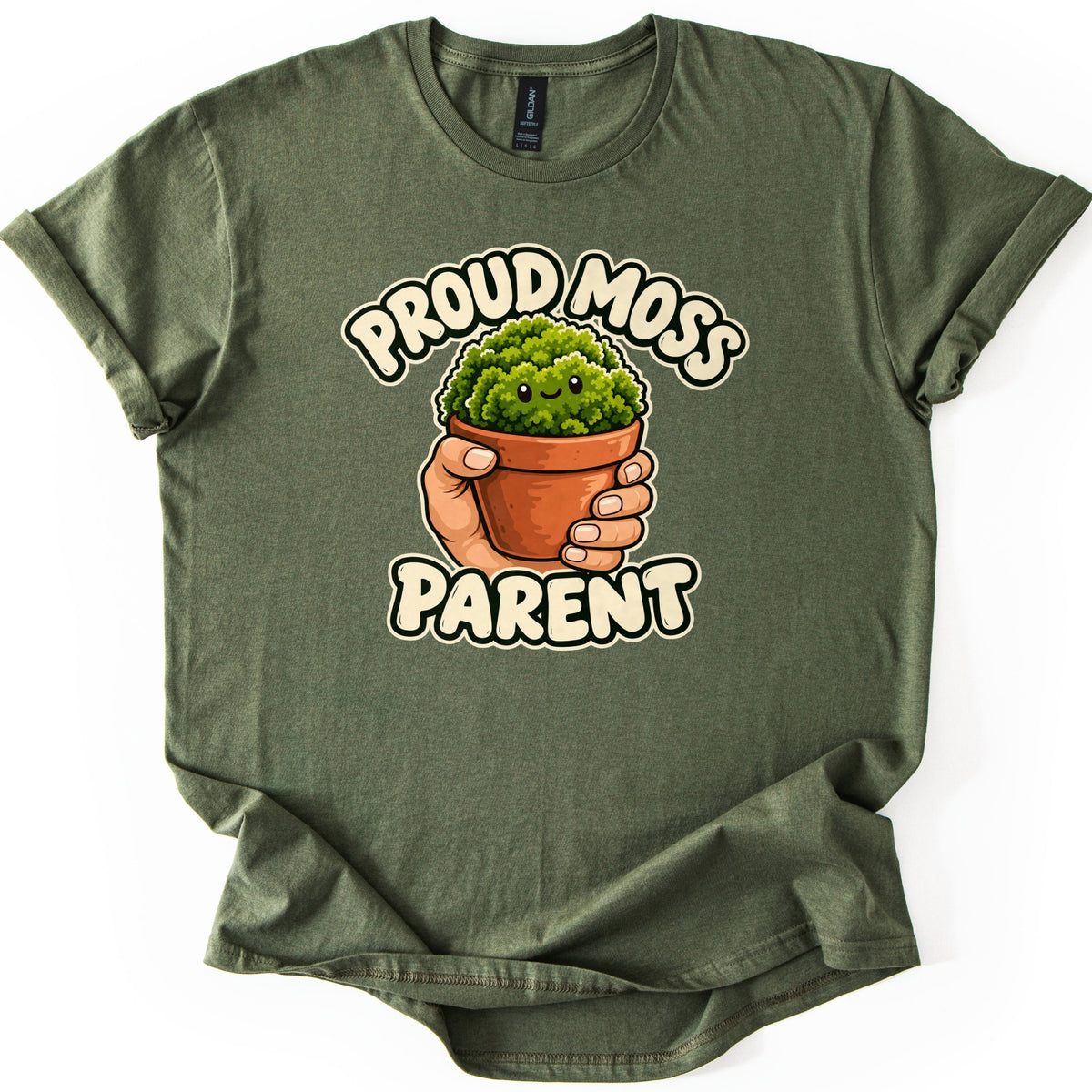 Proud Moss Parent Comfort Colors T-shirt in Military Green, laid flat. A cartoon hand holds a terracotta pot of smiling green moss between the words Proud Moss Parent in cream bubble letters. The shirt has rolled sleeves and lies on a white background.