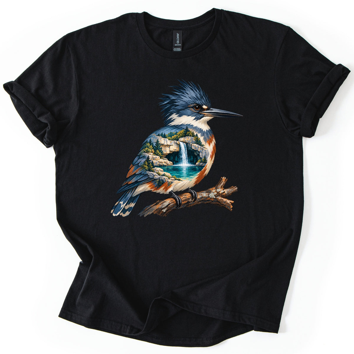 Kingfisher Waterfall Comfort Colors T-shirt in Black, laid flat. A painted kingfisher with a blue crest perches on a branch, its body filled with a waterfall pouring into a turquoise pool among rocks and pine trees. No words. Sleeves rolled, on a white background.