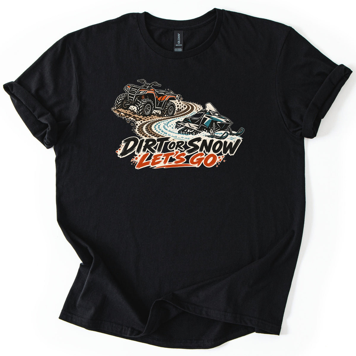 Dirt or Snow Let's Go Comfort Colors T-shirt in Black, laid flat. An orange ATV leaves dirt tracks that become a snowy trail with a teal snowmobile, above the words DIRT OR SNOW LET'S GO in black and orange. The shirt lies on a white background with cuffed sleeves.