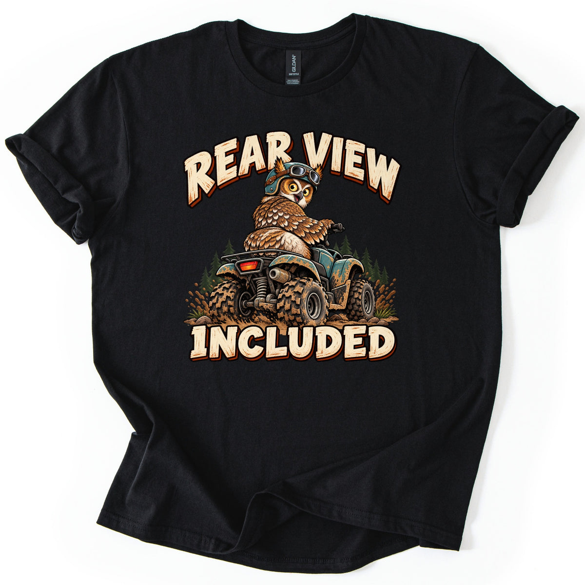 Rear View Included Comfort Colors T-shirt in Black, laid flat. A cartoon owl wearing a helmet and goggles rides a muddy teal ATV through pine trees and splashing mud, glancing back, between the words Rear View Included. The shirt lies on a white surface.