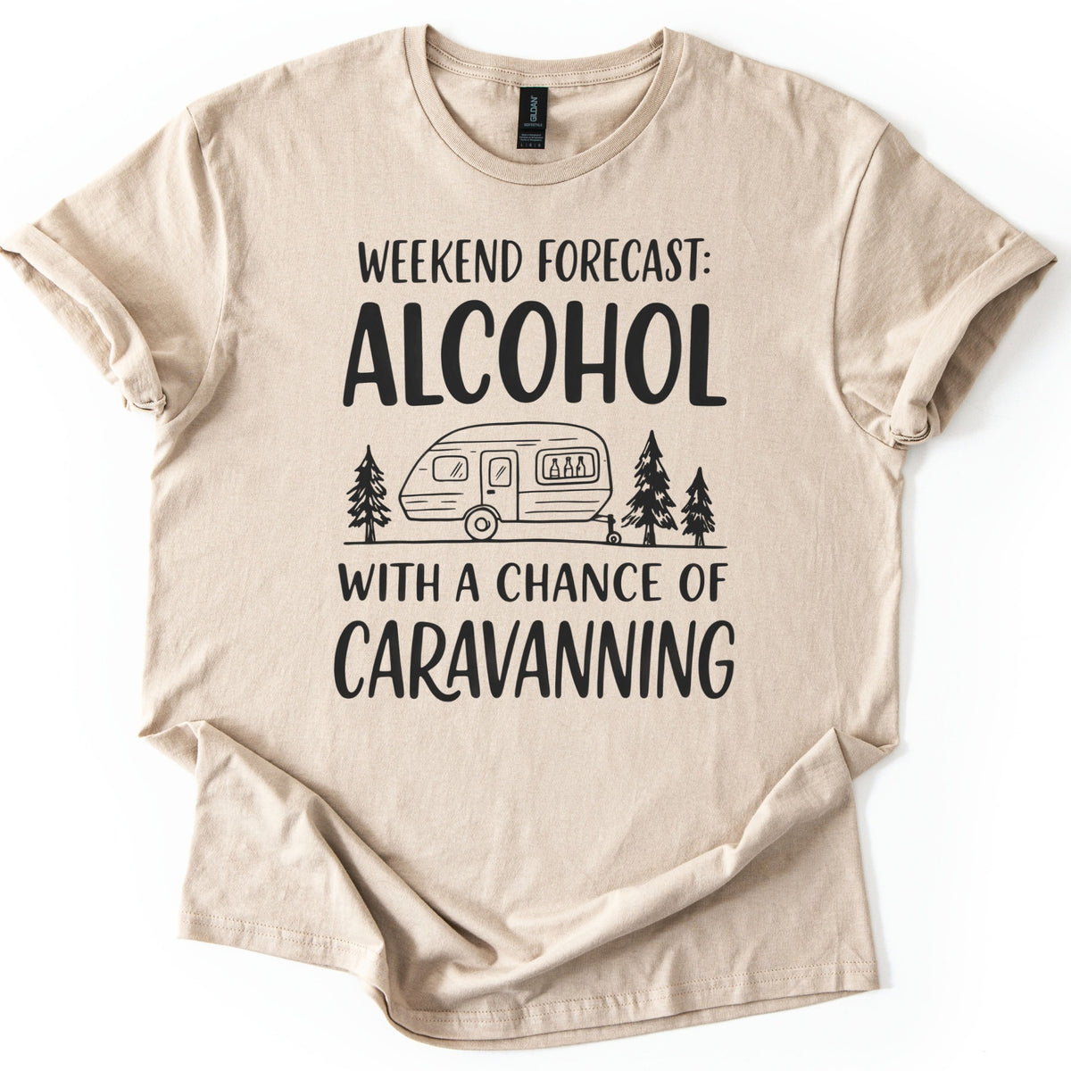 Weekend Forecast Caravanning Comfort Colors T-shirt in Sand, laid flat. Black print reads Weekend Forecast: Alcohol With a Chance of Caravanning around a line drawing of a caravan with bottles in its window between pine trees. Sleeves are cuffed on a white background.