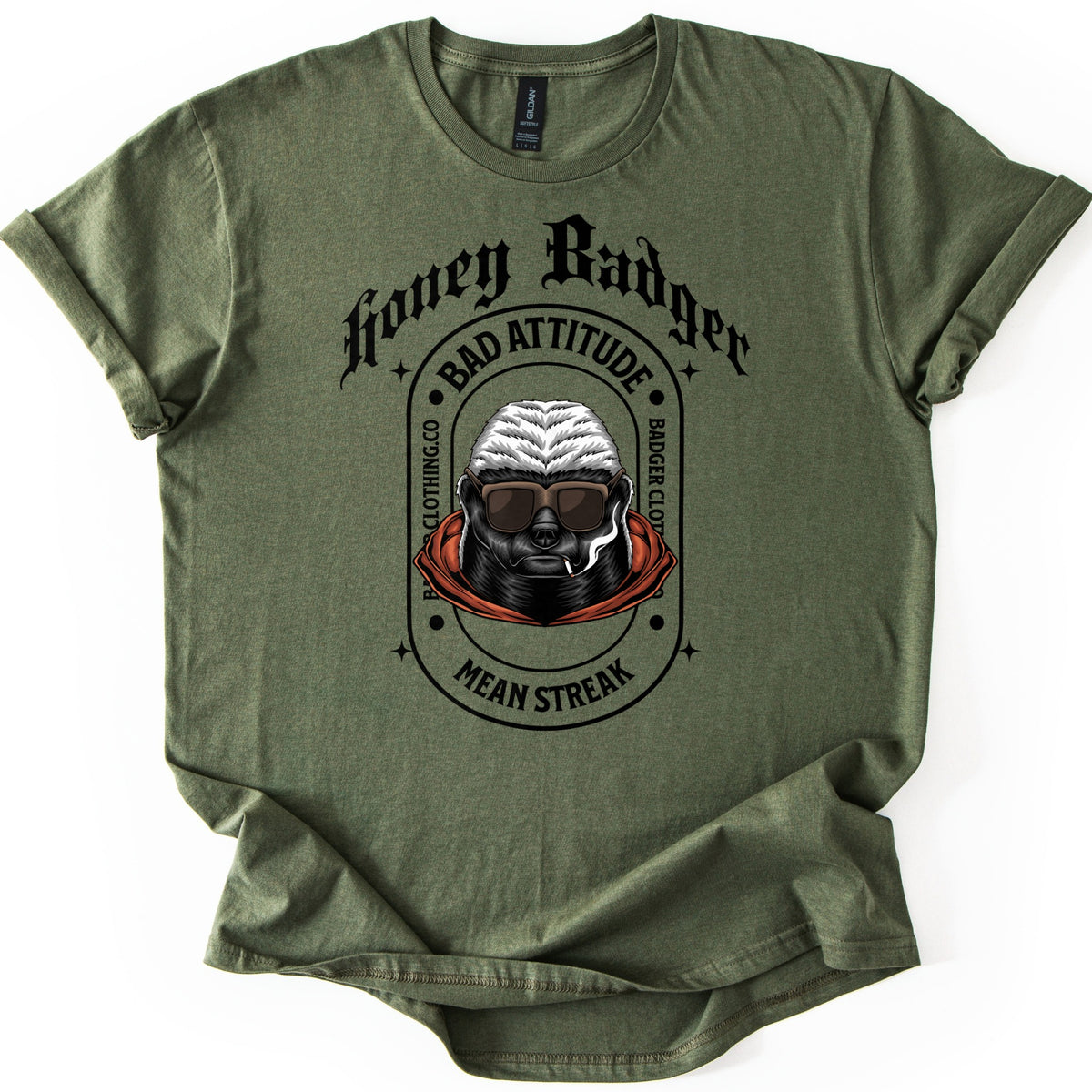 Bad Vibes Badger Comfort Colors T-shirt in Military Green, laid flat. Black print: Honey Badger in gothic letters over an oval badge reading Bad Attitude, Badger Clothing.co and Mean Streak around a honey badger in sunglasses and an orange hood, smoking a cigarette. On a white background.