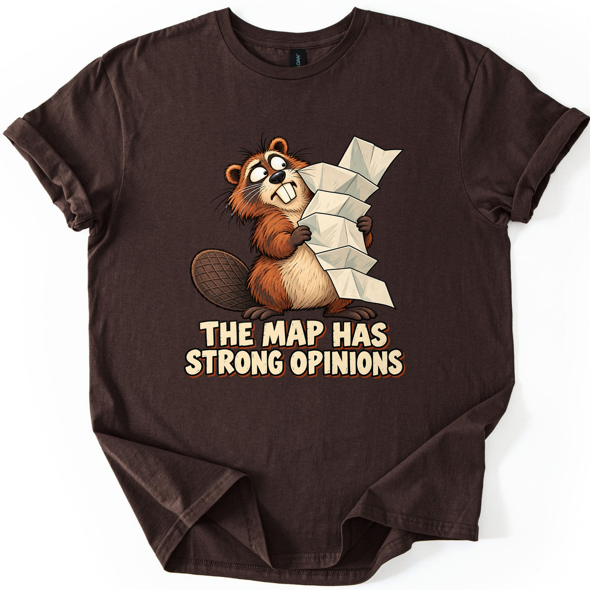 The Map Has Strong Opinions Comfort Colors T-shirt in Dark Chocolate, laid flat. A nervous cartoon beaver with buck teeth grips a tall, unfolding paper map above the words The Map Has Strong Opinions in cream lettering. The shirt is shown on a white background with sleeves rolled.