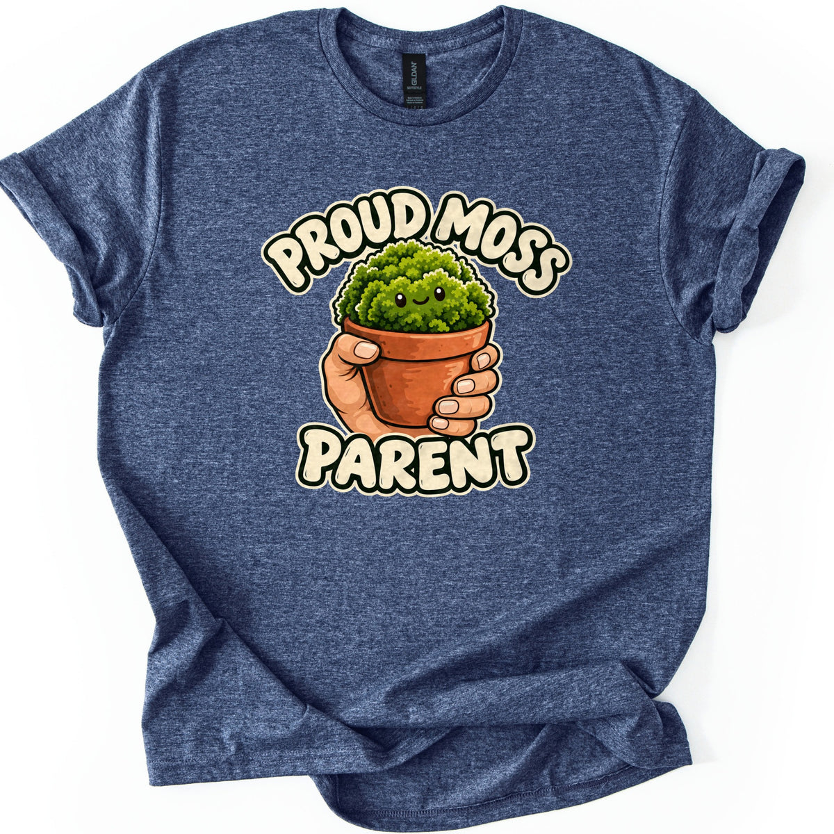 Proud Moss Parent Comfort Colors T-shirt in Heather Navy, laid flat. A cartoon hand holds a terracotta pot of smiling green moss between the words Proud Moss Parent in cream bubble letters. The heathered shirt has cuffed sleeves and lies on a white background.