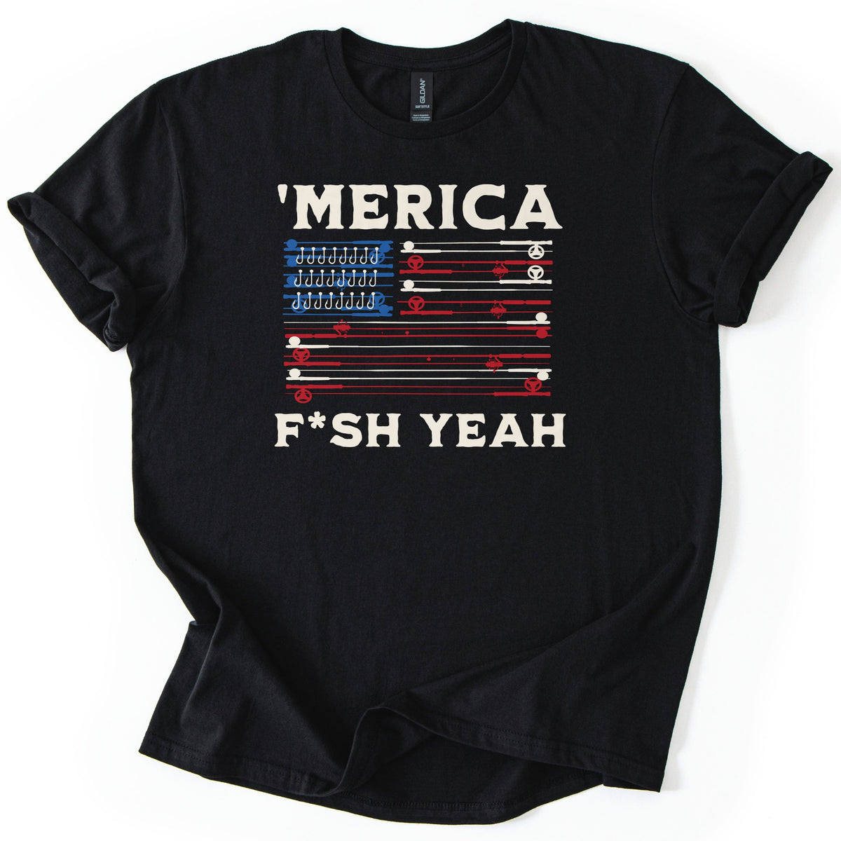 Fish America Fish Yeah Comfort Colors T-shirt in Black, laid flat. Cream letters read 'MERICA above an American flag made of red and cream fishing rods with reels, rows of hooks in its blue corner, and F*SH YEAH below. Cuffed sleeves on a white background.