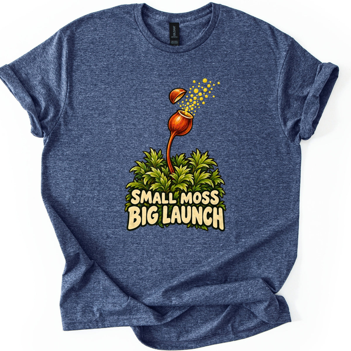 Small Moss Big Launch Comfort Colors T-shirt in Heather Navy, laid flat. An orange moss capsule on a curved stalk rises from leafy green moss, its lid popping off as yellow spores burst out, above the words Small Moss Big Launch. Rolled sleeves, on a white background.