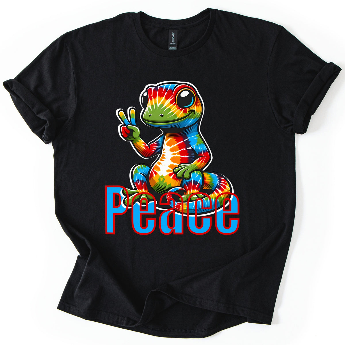 Rainbow Lizard Peace Comfort Colors T-shirt in Black, laid flat. A smiling cartoon lizard with tie-dye rainbow skin sits on its curled tail and flashes a peace sign above the word Peace in blue letters outlined in red. Cuffed sleeves on a white background.