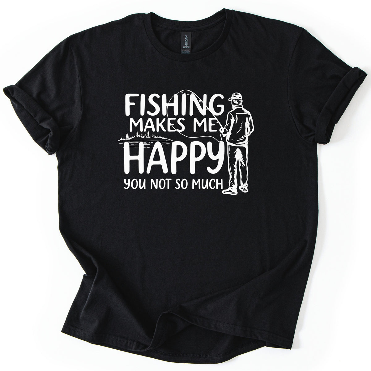 Fishing Makes Me Happy Comfort Colors T-shirt in Black, laid flat. White print reads Fishing Makes Me Happy, You Not So Much, beside a sketch of a man in a cap casting a fishing rod from behind and a lake edged with pine trees. Sleeves are rolled on a white background.