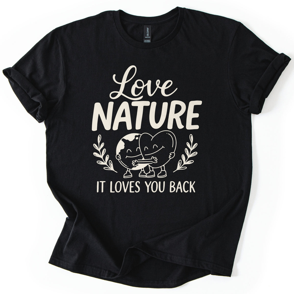 Nature Loves You Back Comfort Colors T-shirt in Black, laid flat. Cream print reads Love NATURE above a smiling cartoon Earth and heart hugging between two leafy sprigs, then IT LOVES YOU BACK. The sleeves are rolled and the shirt lies on a white background.