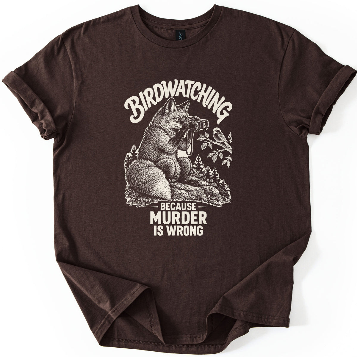 Birdwatching Murder Fox Comfort Colors T-shirt in Dark Chocolate, laid flat. A sketched fox sits on a rock peering through binoculars at a chickadee on a branch, with Birdwatching arched above and Because Murder Is Wrong below, in cream ink. On a white surface, sleeves cuffed.