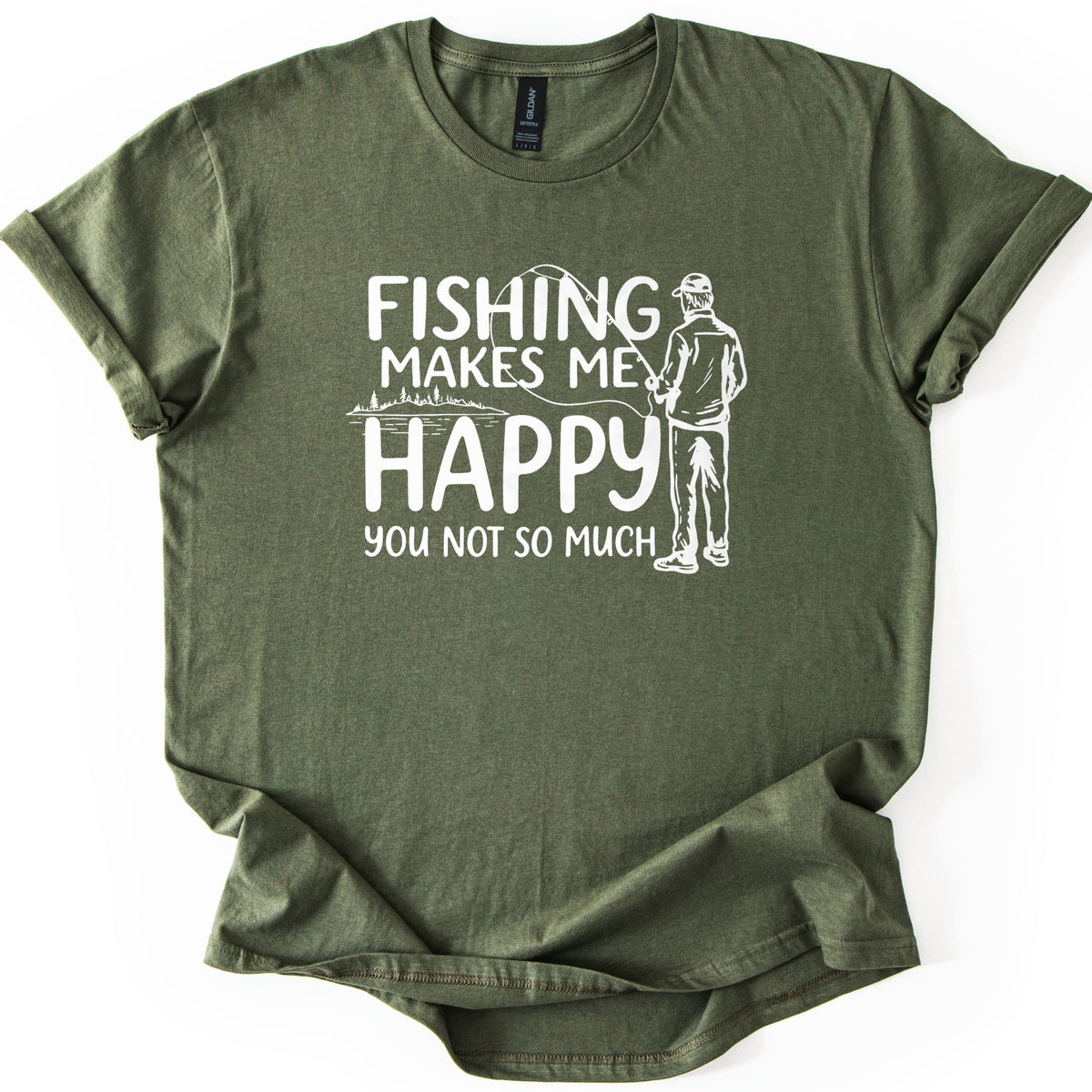 Fishing Makes Me Happy Comfort Colors T-shirt in Military Green, laid flat. White text reads Fishing Makes Me Happy, You Not So Much, next to a drawing of a man in a cap, seen from behind, holding a fishing rod by a tree-lined lake. Shown with rolled sleeves on white.
