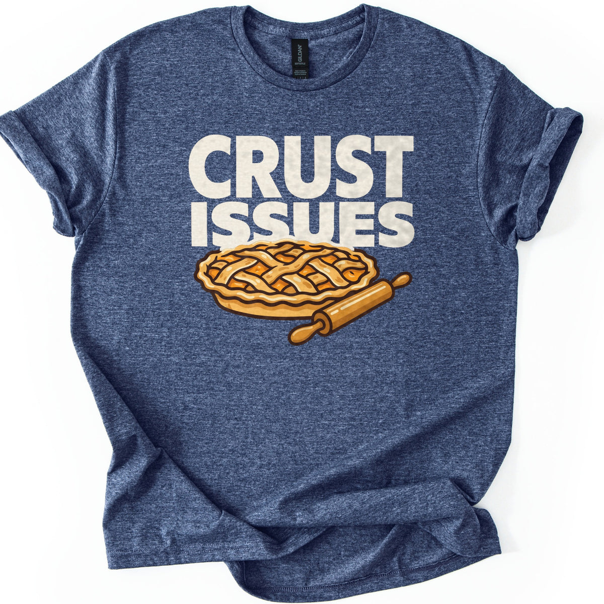 Crust Issues Comfort Colors T-shirt in Heather Navy, laid flat. Cream block letters read CRUST ISSUES above a cartoon lattice-top pie with a wooden rolling pin. The shirt has rolled sleeves and lies on a plain white background.