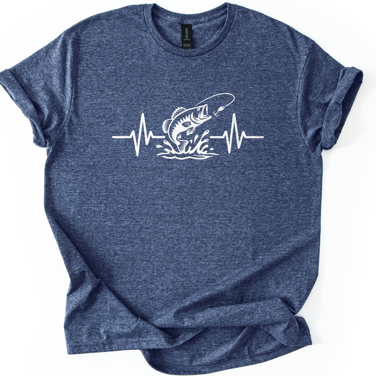 Fishing Heartbeat Comfort Colors T-shirt in Heather Navy, laid flat. A white line drawing of a bass jumping from splashing water at a fishing lure is set in the middle of a heartbeat line on the chest. No words are printed. The shirt lies on a white surface with cuffed sleeves.