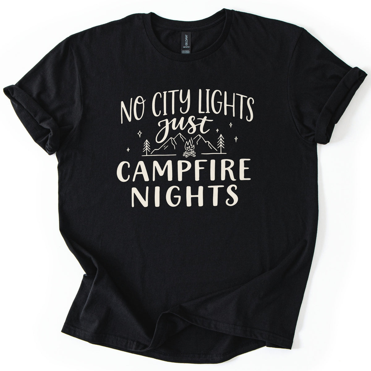 Campfire Nights Comfort Colors T-shirt in Black, laid flat. Cream print reads No City Lights just Campfire Nights, with a line drawing of mountains, pine trees, stars and a small campfire. The sleeves are rolled and the shirt lies on a white background.