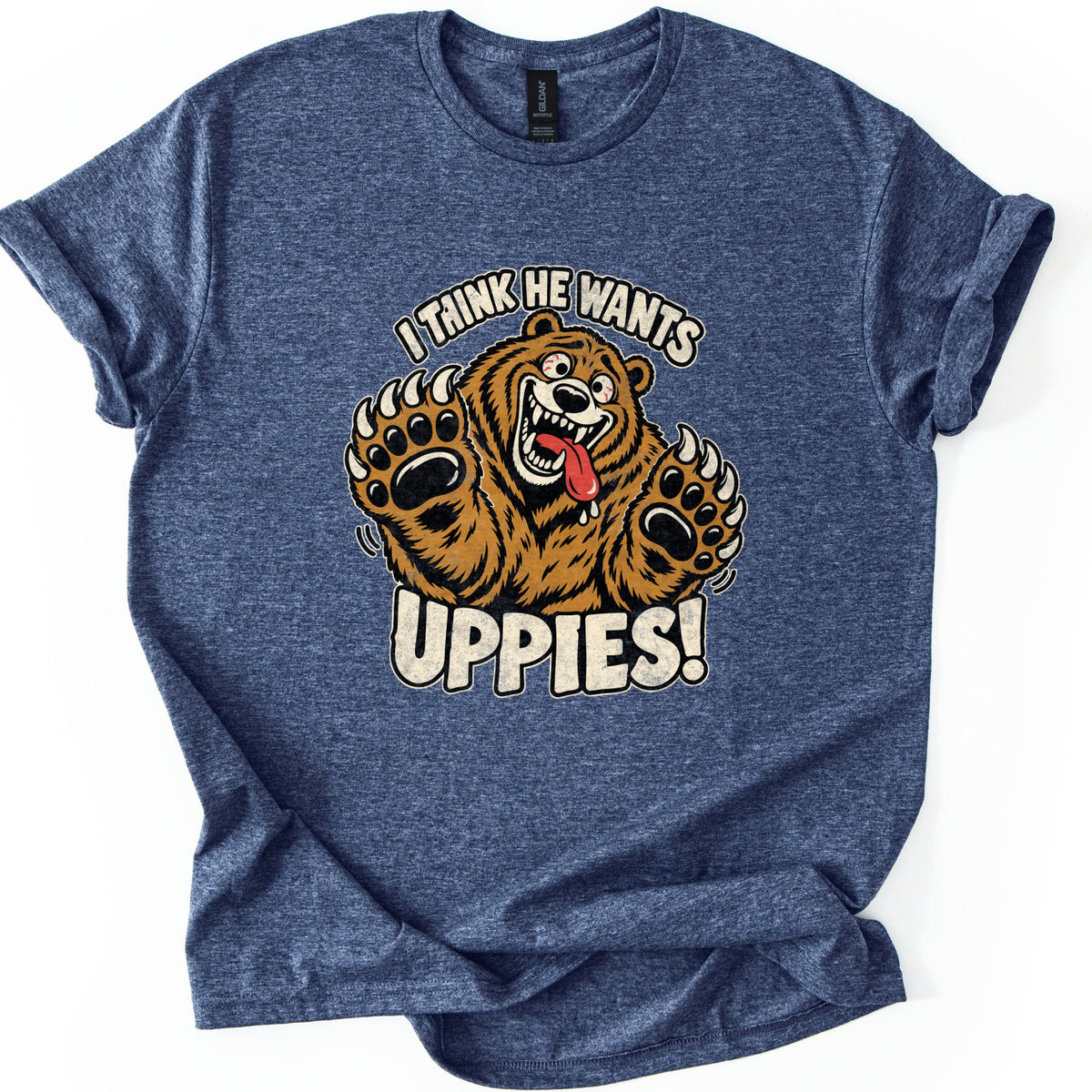I Think He Wants Uppies Comfort Colors T-shirt in Heather Navy, laid flat. A grinning cartoon brown bear with its tongue hanging out raises both clawed paws between the words I Think He Wants and Uppies! The sleeves are cuffed on a white background.