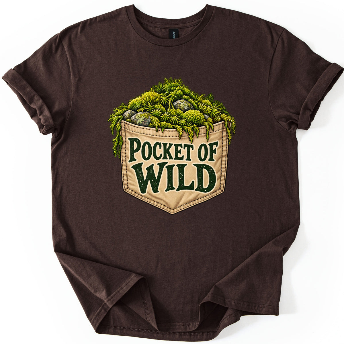 Pocket of Wild Comfort Colors T-shirt in Dark Chocolate, laid flat. A tan stitched pocket heaped with green moss, ferns and lichen-covered stones, printed with the words Pocket of Wild in dark green. The shirt lies flat on white with rolled sleeves.