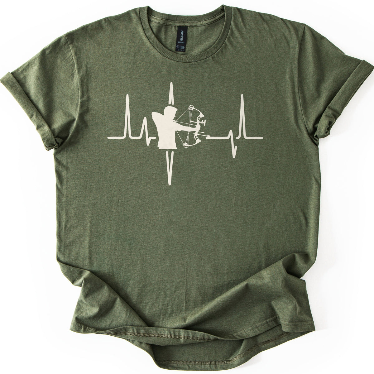 Compound Bow Archer Comfort Colors T-shirt in Military Green, laid flat. A cream silhouette of an archer drawing a compound bow sits in the middle of a heartbeat line across the chest, with no words. The shirt lies on a white background with its sleeves cuffed.