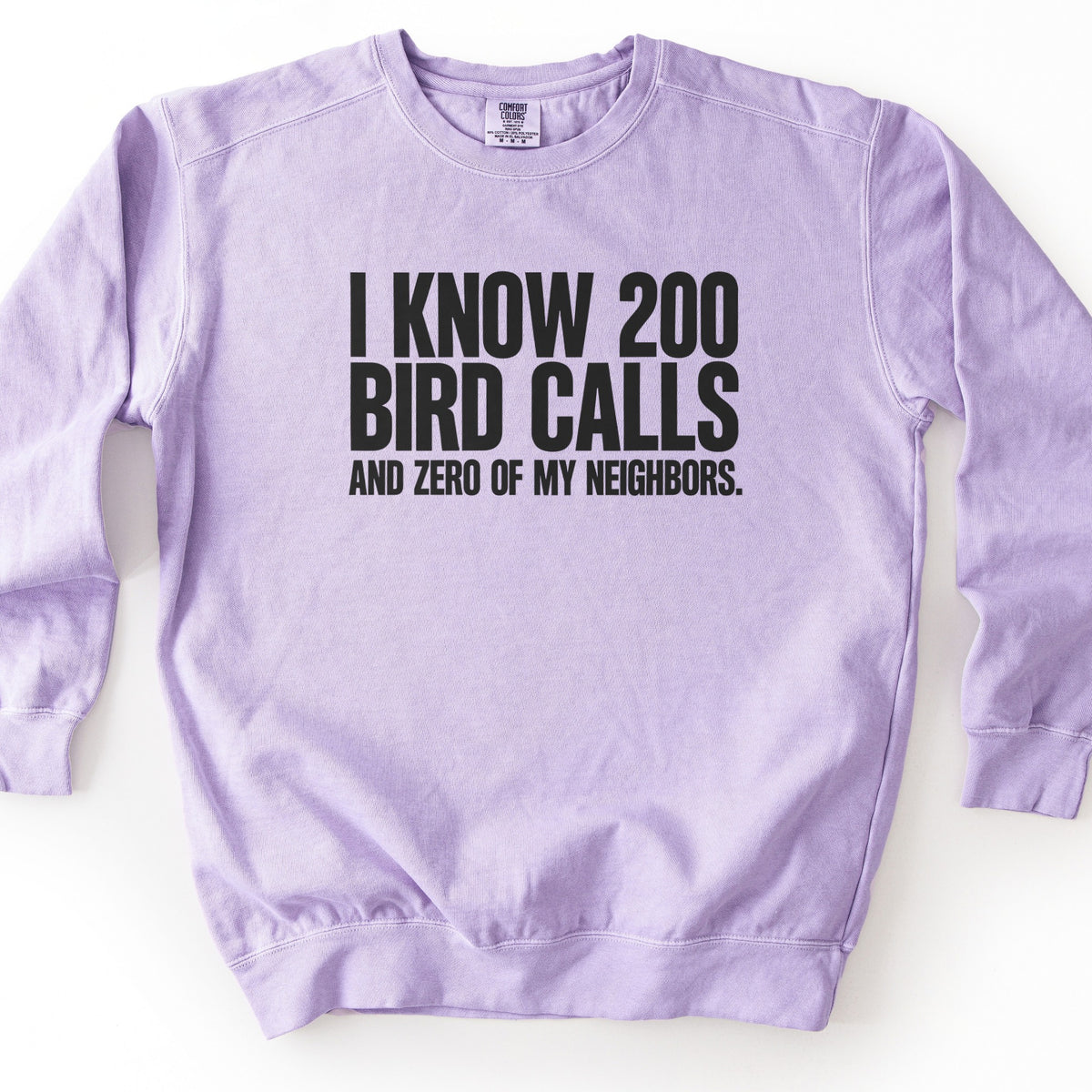 I Know 200 Bird Calls and Zero of My Neighbors Comfort Colors crewneck sweatshirt in Orchid, laid flat. Bold black capital letters across the chest read I Know 200 Bird Calls, with And Zero of My Neighbors. in smaller letters below. The sweatshirt lies on a plain white background.