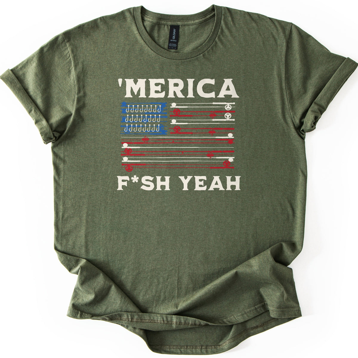 Fish America Fish Yeah Comfort Colors T-shirt in Military Green, laid flat. An American flag of red and cream fishing rods and reels, with rows of hooks in the blue corner, sits between 'MERICA and F*SH YEAH in cream letters. Sleeves rolled, on a white background.