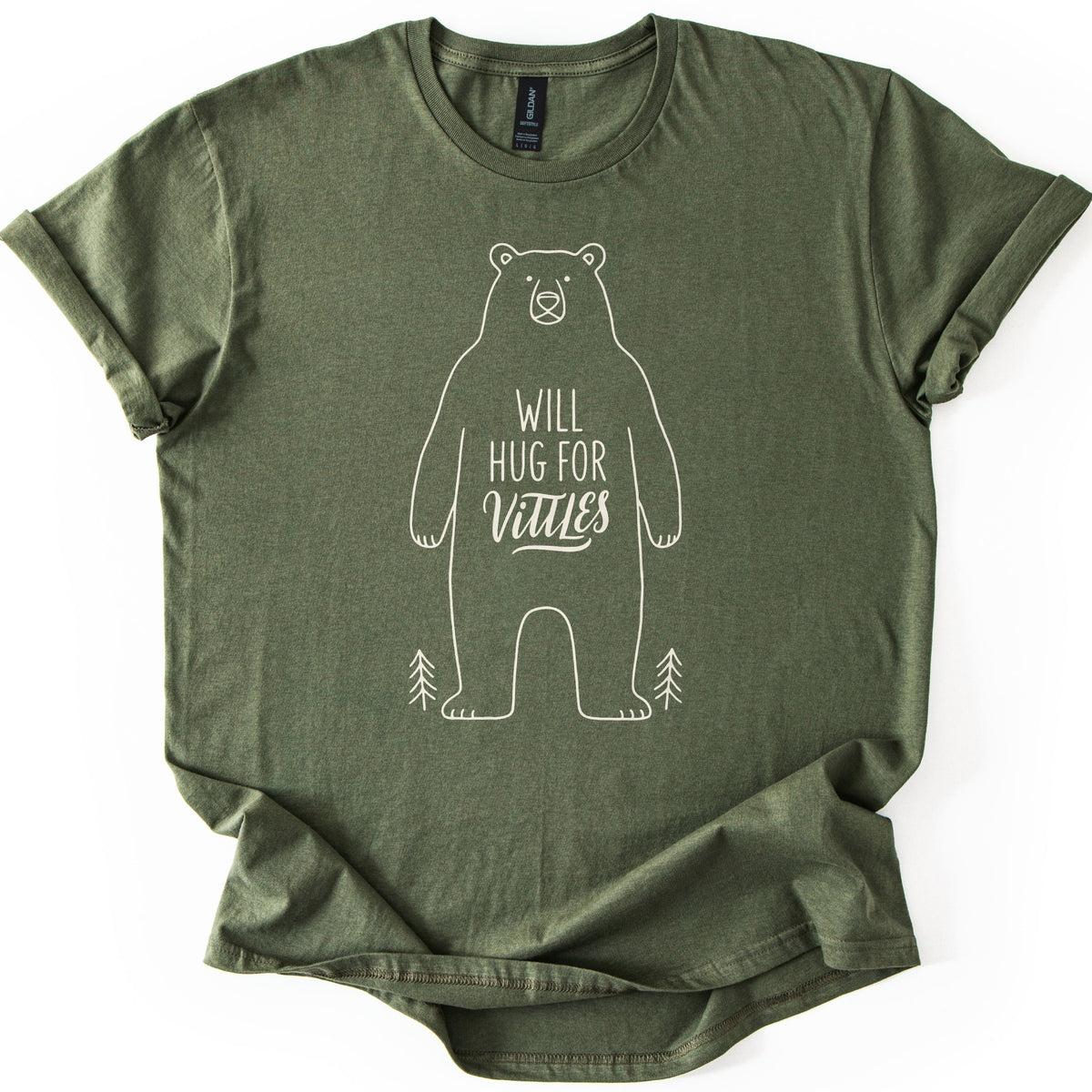 Will Hug For Vittles Bear Comfort Colors T-shirt in Military Green, laid flat. A cream line drawing of a standing bear with the words WILL HUG FOR Vittles on its belly and a small pine tree at each foot. The shirt has rolled sleeves and lies on a white background.