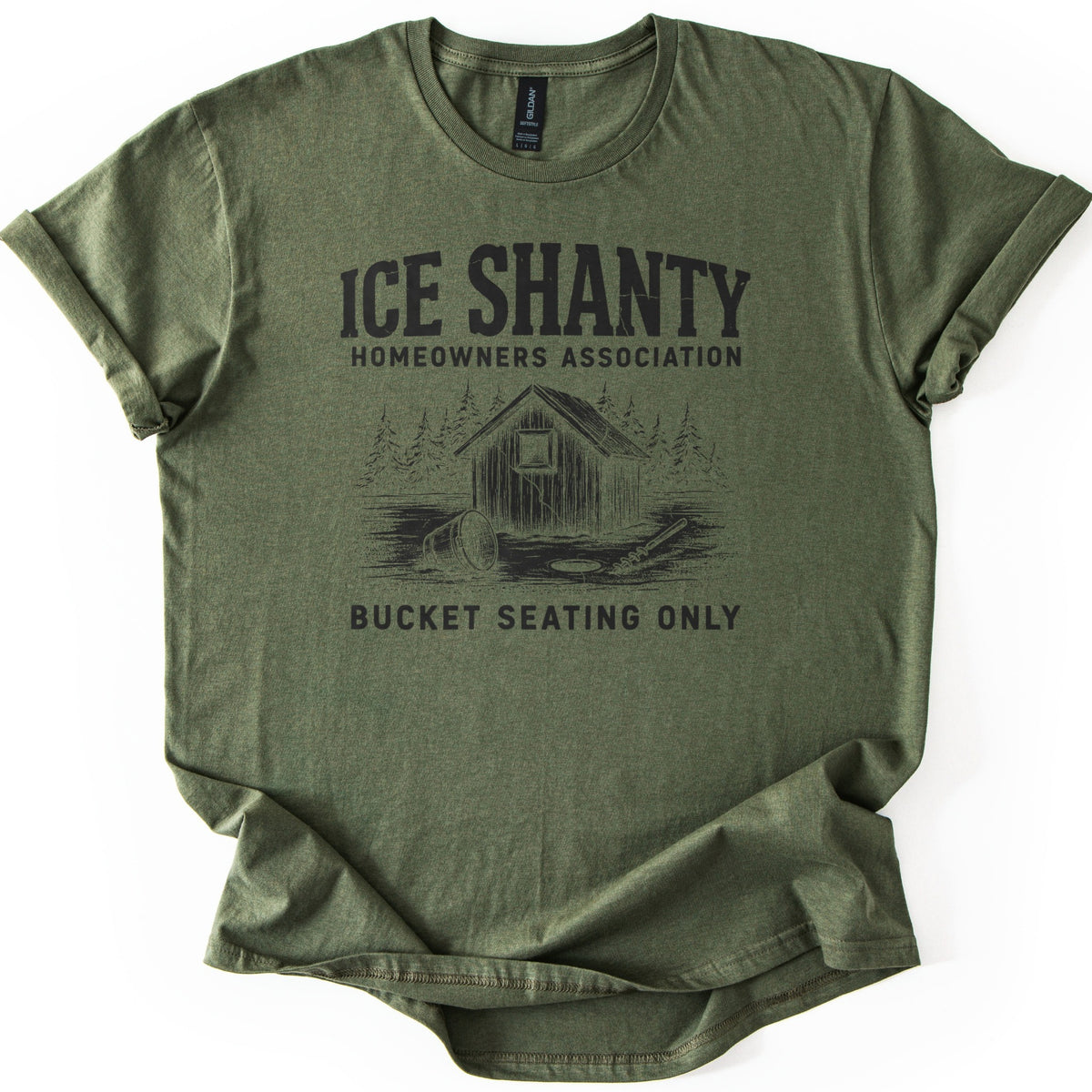 Ice Shanty Homeowners Association Comfort Colors T-shirt in Military Green, laid flat. Black print reads ICE SHANTY, HOMEOWNERS ASSOCIATION above a sketch of a wooden ice shack among pines with a tipped bucket, ice hole and auger, then BUCKET SEATING ONLY. Sleeves cuffed, on white.