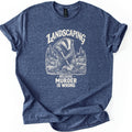 Landscaping Murder Badger Comfort Colors T-shirt in Heather Navy, laid flat. A cream engraving-style badger digs with a shovel among pine trees and rocks, under the arched word Landscaping and above Because Murder Is Wrong. Cuffed sleeves on a white background.
