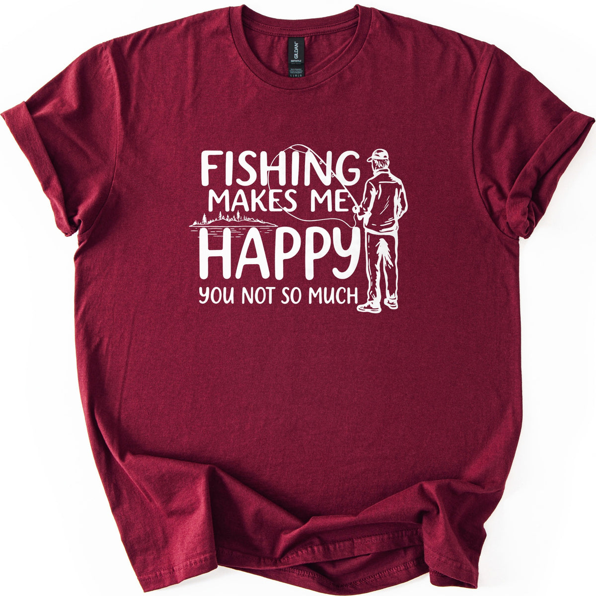 Fishing Makes Me Happy Comfort Colors T-shirt in Maroon, laid flat. White print reads Fishing Makes Me Happy, You Not So Much, with a line drawing of a capped man fishing, seen from behind, and a lakeshore with trees. Sleeves are rolled on a white background.