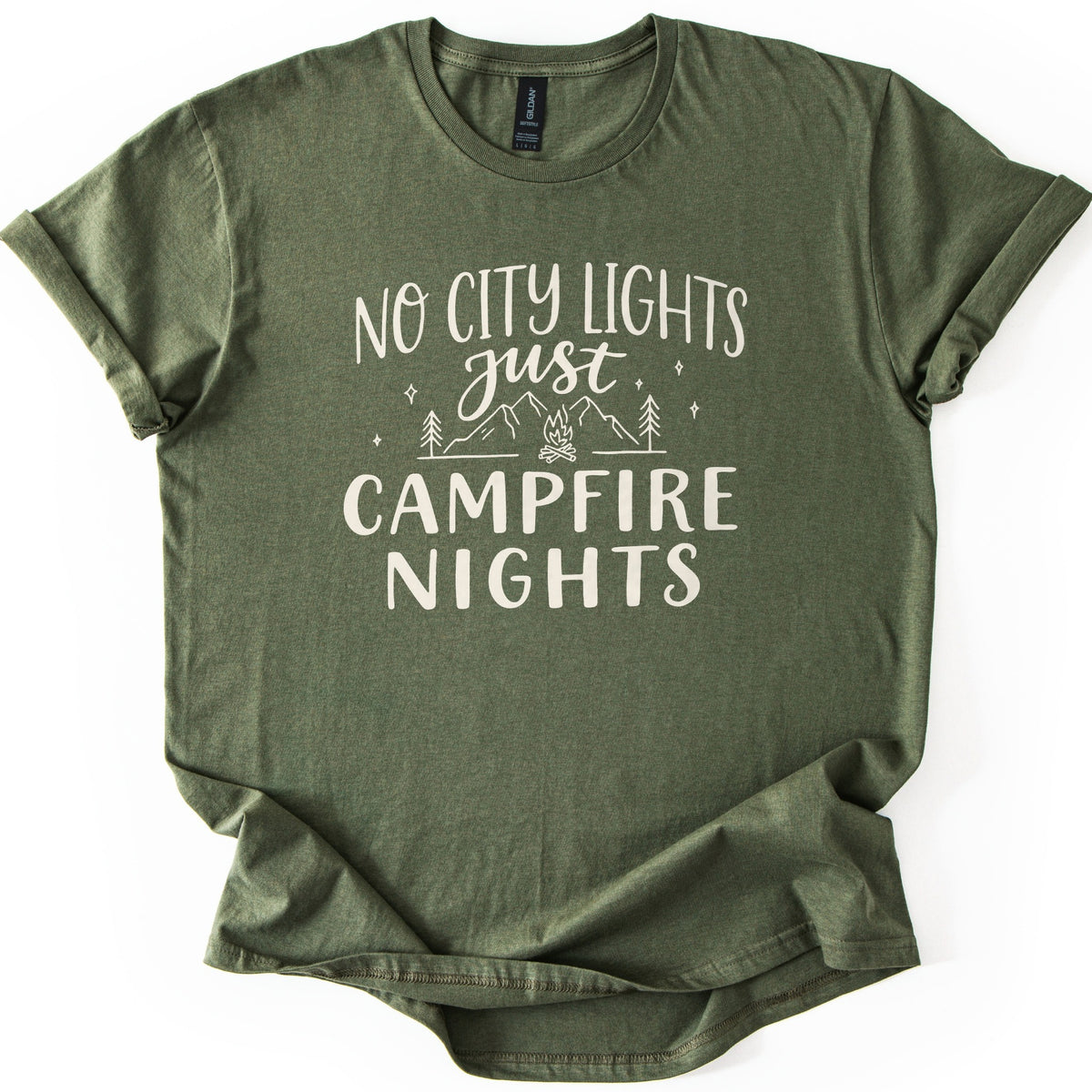 Campfire Nights Comfort Colors T-shirt in Military Green, laid flat. Cream print reads No City Lights just Campfire Nights, with a line drawing of mountains, pine trees, stars and a small campfire. The sleeves are rolled and the shirt lies on a white background.