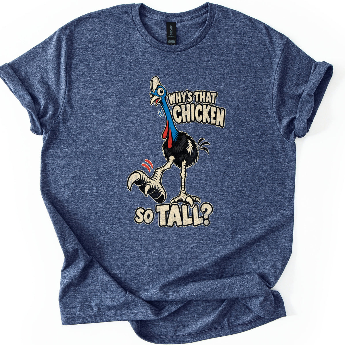 Why's That Chicken So Tall Comfort Colors T-shirt in Heather Navy, laid flat. A cartoon cassowary with a blue neck, red wattles and a black feathered body kicks up a clawed foot beside cream text reading Why's That Chicken So Tall? The shirt lies on white with cuffed sleeves.