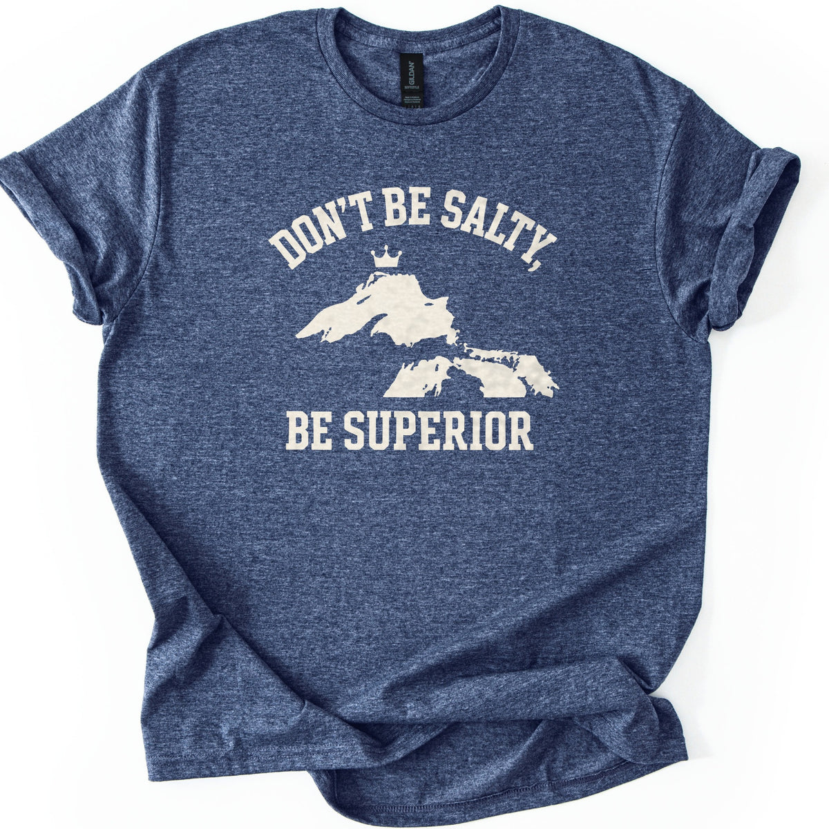 Be Superior Comfort Colors T-shirt in Heather Navy, laid flat. A cream print shows the words Don't Be Salty, arched over a silhouette of the Great Lakes with a small crown above Lake Superior, and Be Superior below. Sleeves are cuffed on a white background.