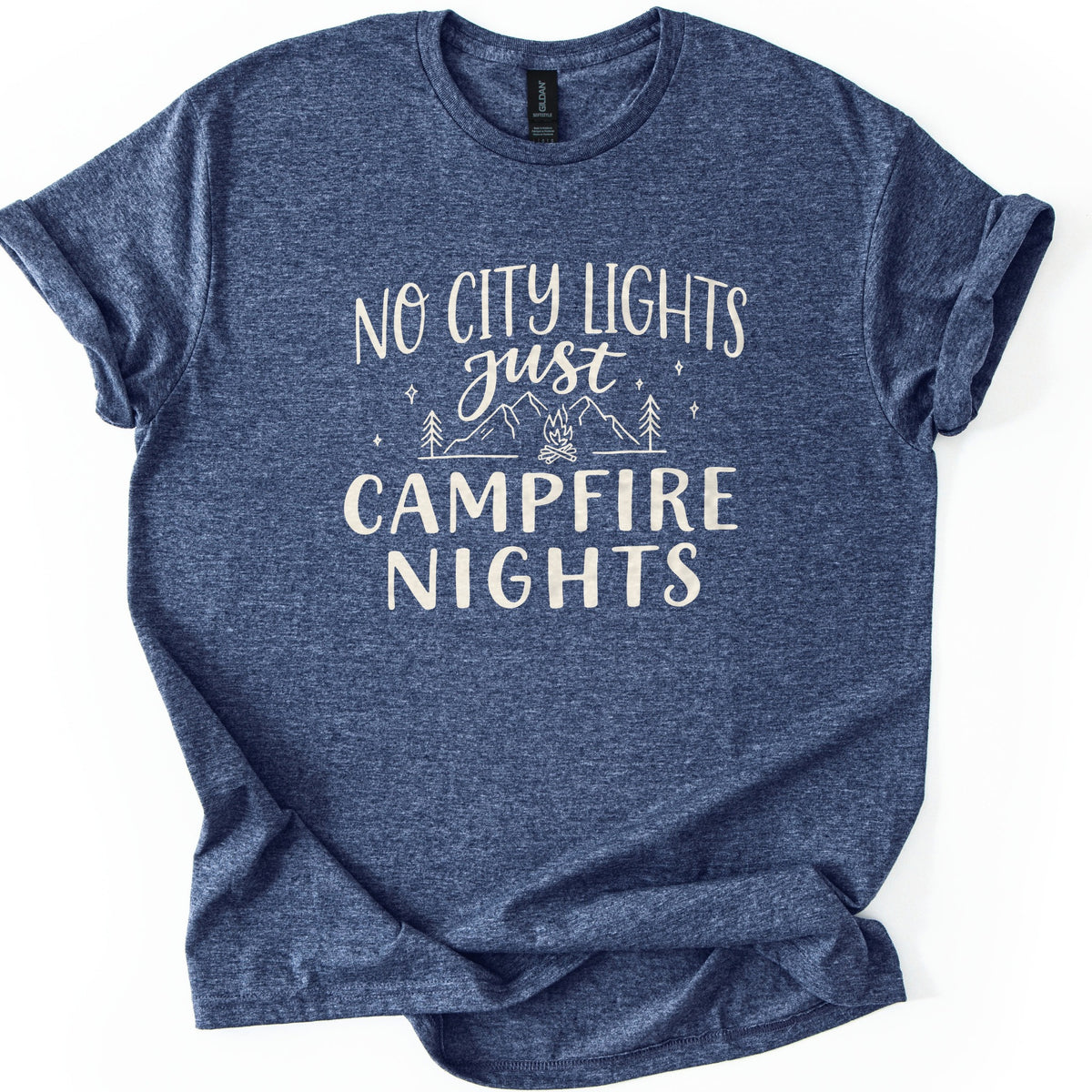 Campfire Nights Comfort Colors T-shirt in Heather Navy, laid flat. Cream print reads No City Lights just Campfire Nights, with a line drawing of mountains, pine trees, stars and a small campfire. The sleeves are rolled and the shirt lies on a white background.