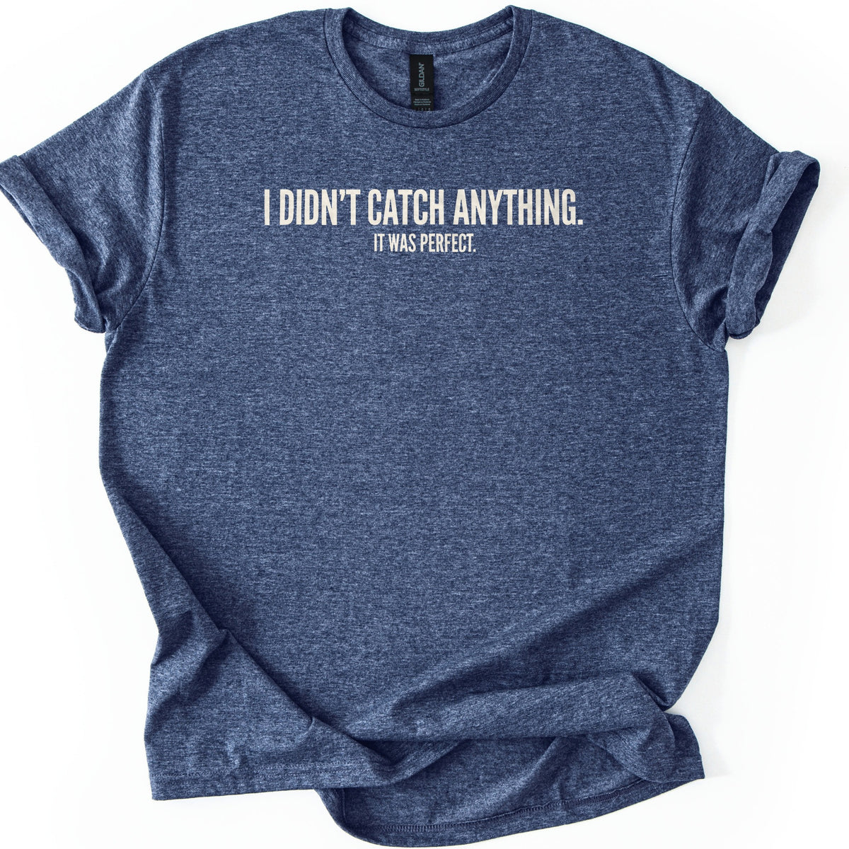 Didn't Catch Anything Comfort Colors T-shirt in Heather Navy, laid flat. Cream block letters across the chest read I DIDN'T CATCH ANYTHING. with smaller text below reading IT WAS PERFECT. The shirt has cuffed sleeves and lies on a white background.