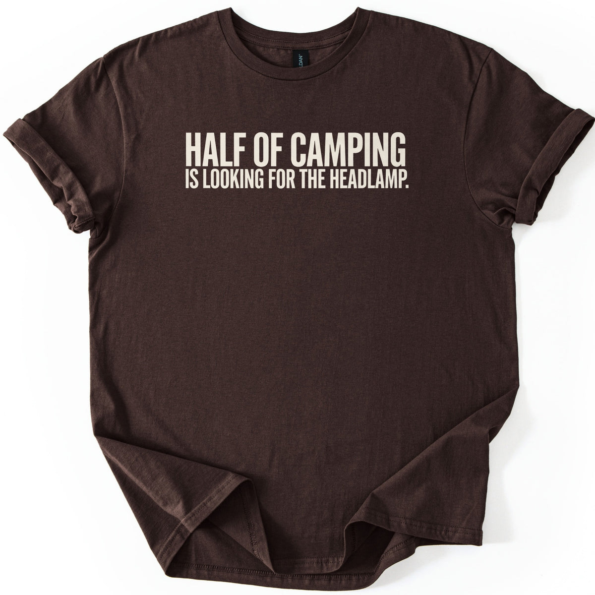 Looking For The Headlamp Comfort Colors T-shirt in Dark Chocolate, laid flat. Bold off-white capital letters across the chest read HALF OF CAMPING, with IS LOOKING FOR THE HEADLAMP. on a smaller line below. The sleeves are cuffed and the shirt lies on a white surface.
