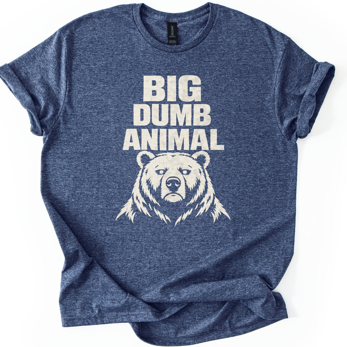 Big Dumb Animal Comfort Colors T-shirt in Heather Navy, laid flat. Bold cream letters read BIG DUMB ANIMAL above a cream illustration of a stern, front-facing bear head with shaggy fur. The sleeves are rolled and the shirt lies on a white background.